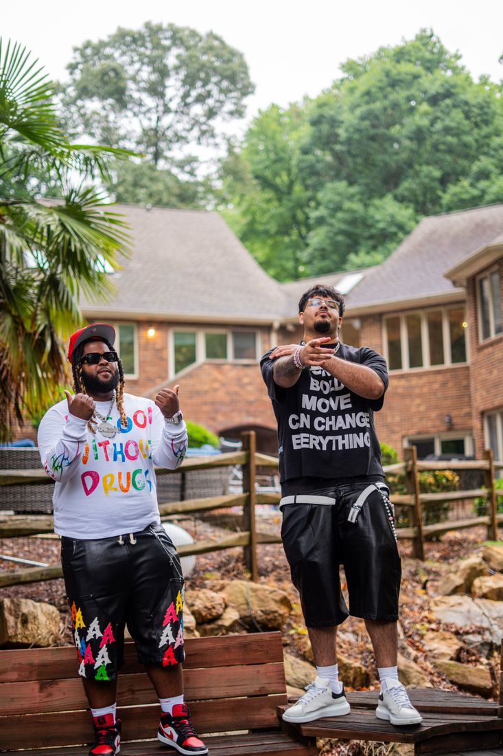 Harman 2x posing outdoors with another artist